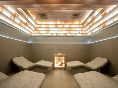 Innenansicht der Salzgrotte im MSC Aurea Spa an Bord der MSC World Asia mit vier ergonomischen Liegen und beleuchteten Salzsteinen an der Decke und in einem Mittelwürfel.