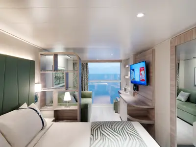 Eine helle, moderne Außenkabine an Bord der MSC World Europa. Ein Bett mit Kopfteil, ein Sofa, ein Schreibtisch mit TV und ein großes Fenster mit Meerblick sind zu sehen.