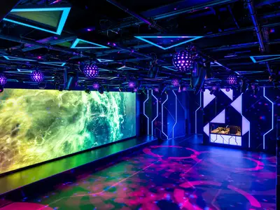Die futuristische Luna Park Arena an Bord der MSC World Europa, mit riesiger LED-Wand, Neon-Beleuchtung und Tanzfläche.