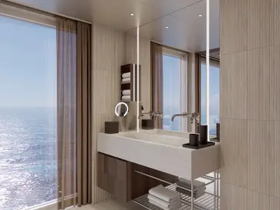 Blick in ein modernes Bad mit Doppelwaschbecken, großer Spiegelwand und einer Verglasung mit Meerblick, Teil einer Suite an Bord der Norwegian Aqua.