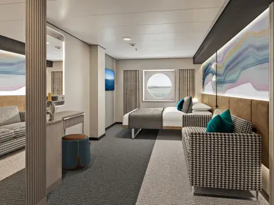 Moderne Aussenkabine an Bord der Norwegian Aura. Rundes Fenster mit Meerblick, Doppelbett und Sofa mit Hahnentrittmuster. Eine helle Kunstinstallation ziert die Wand. Die Kabine ist ohne Personen zu sehen.