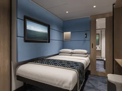 Moderne Einzelkabine an Bord der Norwegian Aura. Blaue Polsterwände, Einzelbett, TV mit Meerblick. Holztür zu einem Badezimmer mit Spiegel.