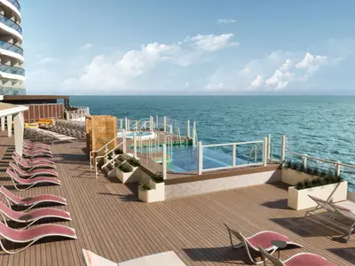 Panoramablick auf das weitläufige Sonnendeck der Norwegian Aura mit roten Liegestühlen, mehreren Pools und Whirlpool, direkt am offenen Meer.