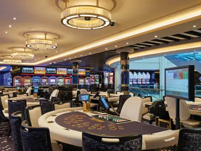 Das Casino der Norwegian Bliss bietet Spieltische und Slot Machines. Elegante Beleuchtung und modernes Design prägen die luxuriöse Atmosphäre.
