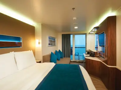 Helle Balkonkabine an Bord der Norwegian Breakaway mit grossem Bett, Sitzbereich, TV und Zugang zum Balkon mit weitem Meerblick.