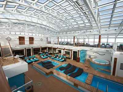 Weitwinkelaufnahme des stilvollen, überdachten Haven Pool Bereichs an Bord der Norwegian Breakaway. Mehrere Pools, Jacuzzi und viele Liegemöglichkeiten laden zum Entspannen ein.