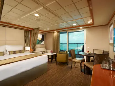 Luxuriöse Suite an Bord der Norwegian Dawn mit grossem Bett, gemütlicher Sitzecke und privatem Balkon. Moderne, helle Einrichtung mit Meerblick.