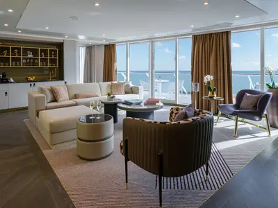 Detailaufnahme eines eleganten Wohnzimmers der Premier Owner's Suite an Bord der Norwegian Encore mit Sofa, Sesseln, Beistelltischen und großem Meerblick-Balkon.