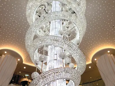 Ein beeindruckender, spiralförmiger Kristallkronleuchter erstreckt sich von der Decke des Atriums an Bord der Norwegian Epic. Die Decke ist mit unzähligen kleinen Lichtern versehen, die einen Sternenhimmel simulieren.
