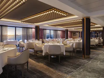 Ein luxuriöses Restaurant an Bord der Norwegian Epic mit weiß gedeckten Tischen und bequemen Stühlen. Große Fenster bieten einen malerischen Blick auf das Meer und den Sonnenuntergang. Warme Deckenbeleuchtung erhellt den Raum.