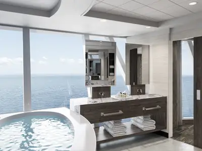 Luxuriöses Badezimmer an Bord der Norwegian Epic Owners Suite. Badewanne mit Meerblick, große Fenster. Doppelwaschtisch aus Marmor und Holz, Spiegel und gestapelte Handtücher sichtbar.