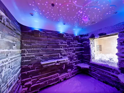 Die Schneekammer der Norwegian Escape. Wände und Boden sind mit Kunstschnee und Eiszapfen bedeckt, in blauem und violettem Licht. Eine Sternenlicht-Decke und ein verschneites Fenster prägen den Raum.