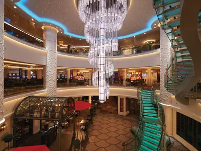 Das opulente Atrium der Norwegian Getaway mit riesigem, glitzerndem Kronleuchter im Zentrum. Beleuchtete Glas-Treppen, dekorative Säulen und mehrere Ebenen mit Casinos und Restaurants sind sichtbar.