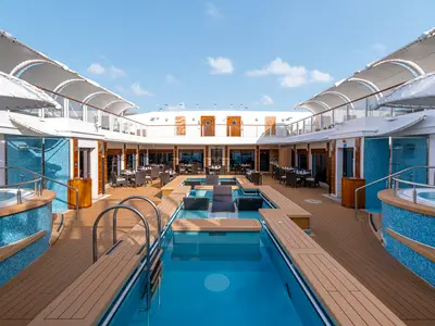 Luxuriöser Poolbereich 'The Haven Courtyard' an Bord der Norwegian Getaway: Pool mit Lounge-Sesseln, Whirlpools und Essbereiche auf dem sonnigen Deck.