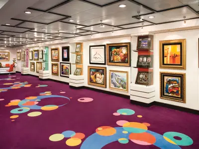Die Kunstgalerie der Norwegian Jade präsentiert gerahmte Gemälde und Skulpturen. Der purpurfarbene Teppich mit bunten Kreisen schafft eine lebhafte, moderne Atmosphäre an Bord.