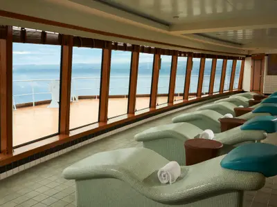Die ThermalSuite der Norwegian Jade. Komfortable Liegen mit Meerblick durch große Panoramafenster. Helle Farben und ruhige Stimmung zum Entspannen.