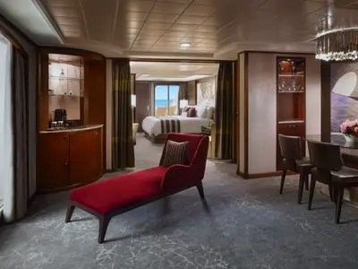 Geräumige Owners Suite an Bord der Norwegian Jewel mit Wohnbereich, Schlafzimmer, Meerblick vom Balkon und elegantem Interieur.