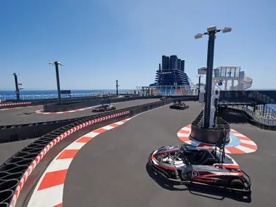 Der Joy Speedway, eine Go-Kart-Strecke an Bord der Norwegian Joy. Drei Karts stehen auf der Bahn mit rot-weißen Kurven. Meer und Himmel im Hintergrund.