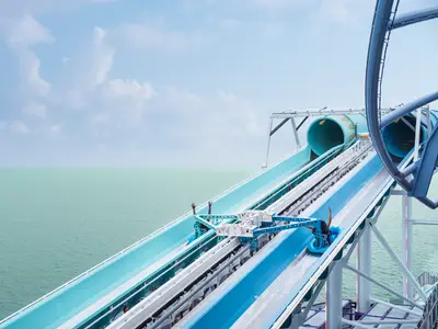 Der AquaSlideCoaster der Norwegian Luna über dem Meer. Eine Person rutscht auf einem Reifen die steile Bahn in einen Tunnel. Weites Meer unter blauem Himmel.