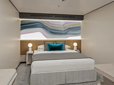 Moderne Innenkabine an Bord der Norwegian Luna mit Doppelbett. Über dem braunen Kopfteil ein großes, beleuchtetes abstraktes Kunstwerk. Minimalistisches Design.