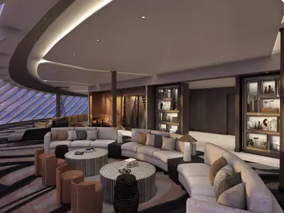 Elegante Observation Lounge an Bord der Norwegian Luna. Bequeme, runde Sofas, stilvolle Tische und grosse Panoramafenster. Moderne Einrichtung, dekorative Regale und warme Beleuchtung.