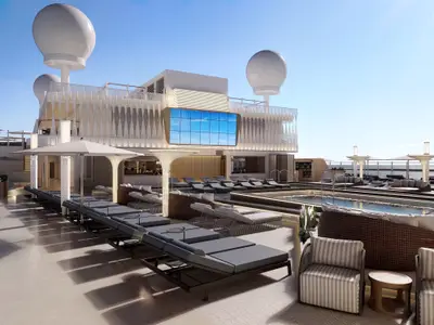 Der helle Poolbereich an Deck der Norwegian Luna zeigt Reihen von Sonnenliegen, bequeme Loungemöbel und einen grossen Pool unter strahlend blauem Himmel. Eine digitale Leinwand an der Schiffswand zeigt ein Himmelsbild.