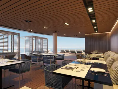 Ein elegantes Aussenrestaurant auf der Norwegian Luna mit zahlreichen gedeckten Tischen und komfortablen Stühlen. Im Hintergrund sind Sonnenliegen und das offene Meer unter blauem Himmel zu sehen. Holzverkleidungen schaffen eine warme Atmosphäre.