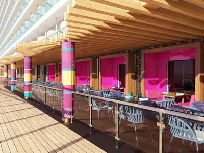 Eine Außenansicht des farbenfrohen Spezialitätenrestaurants an Bord der Norwegian Luna. Helle Holzböden und -decken, Säulen in Pink, Türkis und Gelb, und Tische mit blauen Stühlen laden zum Verweilen ein.
