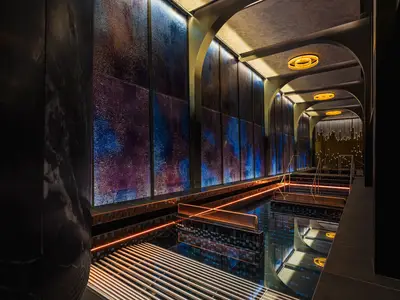 Luxuriöser Spa-Pool an Bord der Norwegian Luna. Schimmernde Wände, farbige Beleuchtung und elegante gewölbte Architektur.