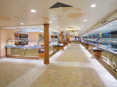 Weitläufiges Garden Café Buffet an Bord der Norwegian Pearl, mit langen Essensstationen unter Glasabdeckungen. Heller Fliesenboden und Decke mit Wolkenmotiven. Keine Personen sichtbar.