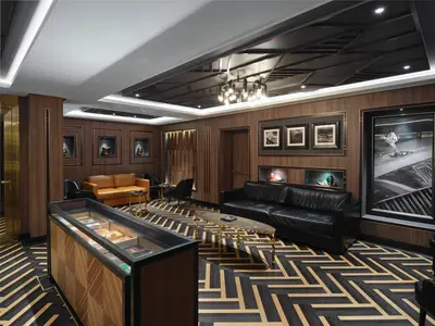 Die elegante Zigarrenlounge an Bord der Norwegian Prima. Dunkle Ledersofas, Holzwände, ein gemusterter Holzboden und eine Vitrine prägen den Raum.