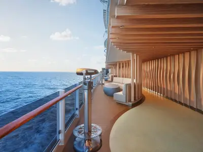 Blick auf die moderne Outdoor-Lounge La Terraza an Bord der Norwegian Prima. Holzverkleidungen, bequeme Sofas und ein Fernrohr bieten weite Sicht auf das offene Meer und den Himmel.
