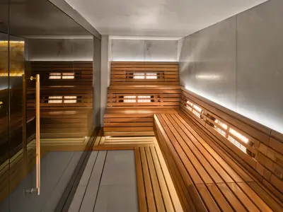 Moderne Infrarot-Sauna an Bord der Norwegian Prima. Helles Holz vertäfelt Wände und Bänke, mit sichtbaren Heizelementen. Indirektes Licht erzeugt eine entspannte Atmosphäre.