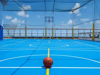 Blauer Basketballplatz an Bord der Norwegian Sky mit einem Basketball. Meerblick und blauer Himmel im Hintergrund.