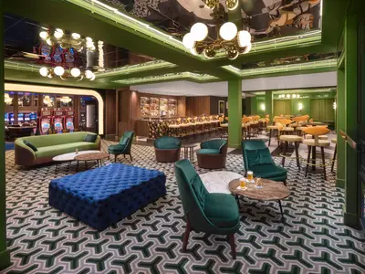Blick in eine moderne Bar-Lounge an Bord der Norwegian Spirit, mit bequemen Sitzen, einer gut ausgestatteten Bar und Blick auf Spielautomaten im Casino.