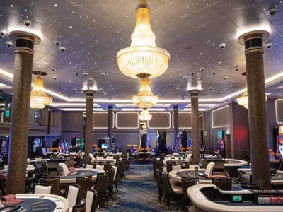 Casino der Norwegian Spirit. Spieltische, Slot-Maschinen, große Kronleuchter, Sternendecke mit Kameras. Luxuriöser Innenbereich.