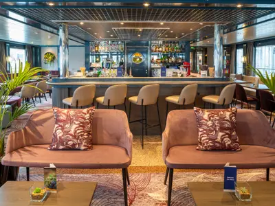 Moderne Bar-Lounge auf der Belvedere. Mit bequemen Sofas, Tischen und einer gut bestückten Bar mit Hockern. Große Fenster bieten Weitblick auf die Umgebung des Schiffes.
