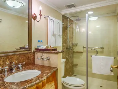 Badezimmer an Bord der Mekong Navigator: Waschtisch mit Marmor, Spiegel, Leuchte, Glasdusche, WC. Ein Handtuch trägt den Schiffsnamen.