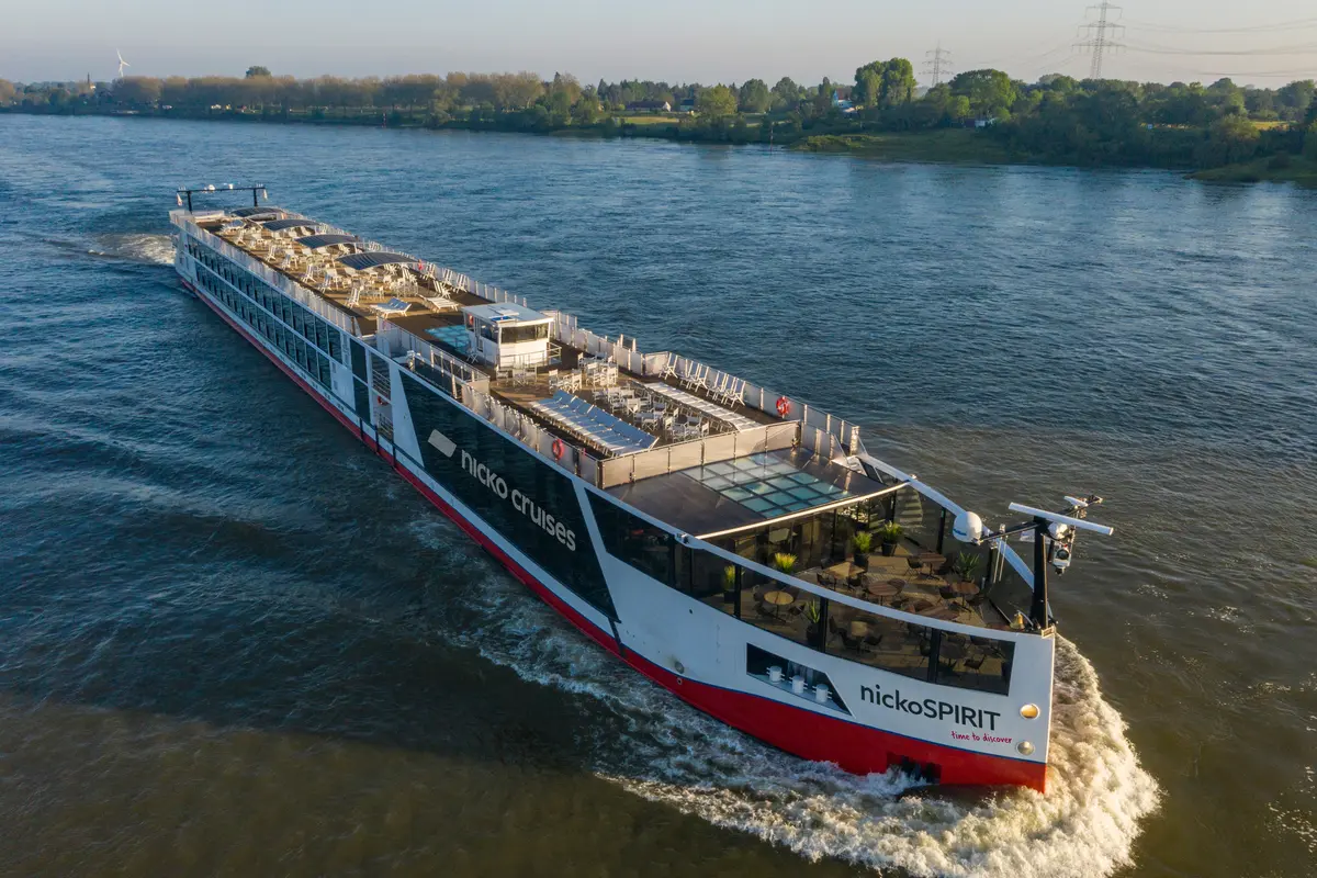 Das Flusskreuzfahrtschiff nickoSPIRIT fährt bei Tageslicht auf einem Fluss, aus der Luft aufgenommen.