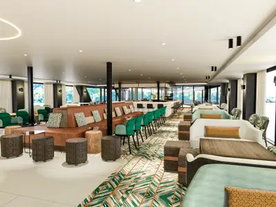 Blick in die moderne Lounge des Flusskreuzfahrtschiffs nickoSPIRIT. Verschiedene Sitzgruppen, eine Bar und große Fenster mit Flussblick prägen den Raum.