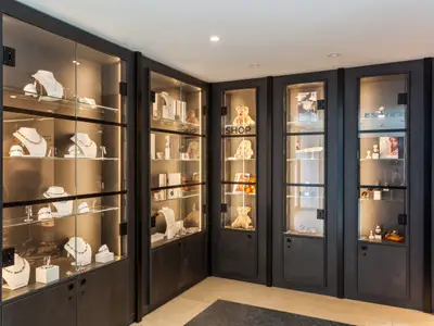 Innenansicht der Bord-Boutique auf dem Flusskreuzfahrtschiff nickoSPIRIT. Beleuchtete Glasvitrinen präsentieren Schmuck, Uhren, Sonnenbrillen und Teddybären in einem modernen Design.