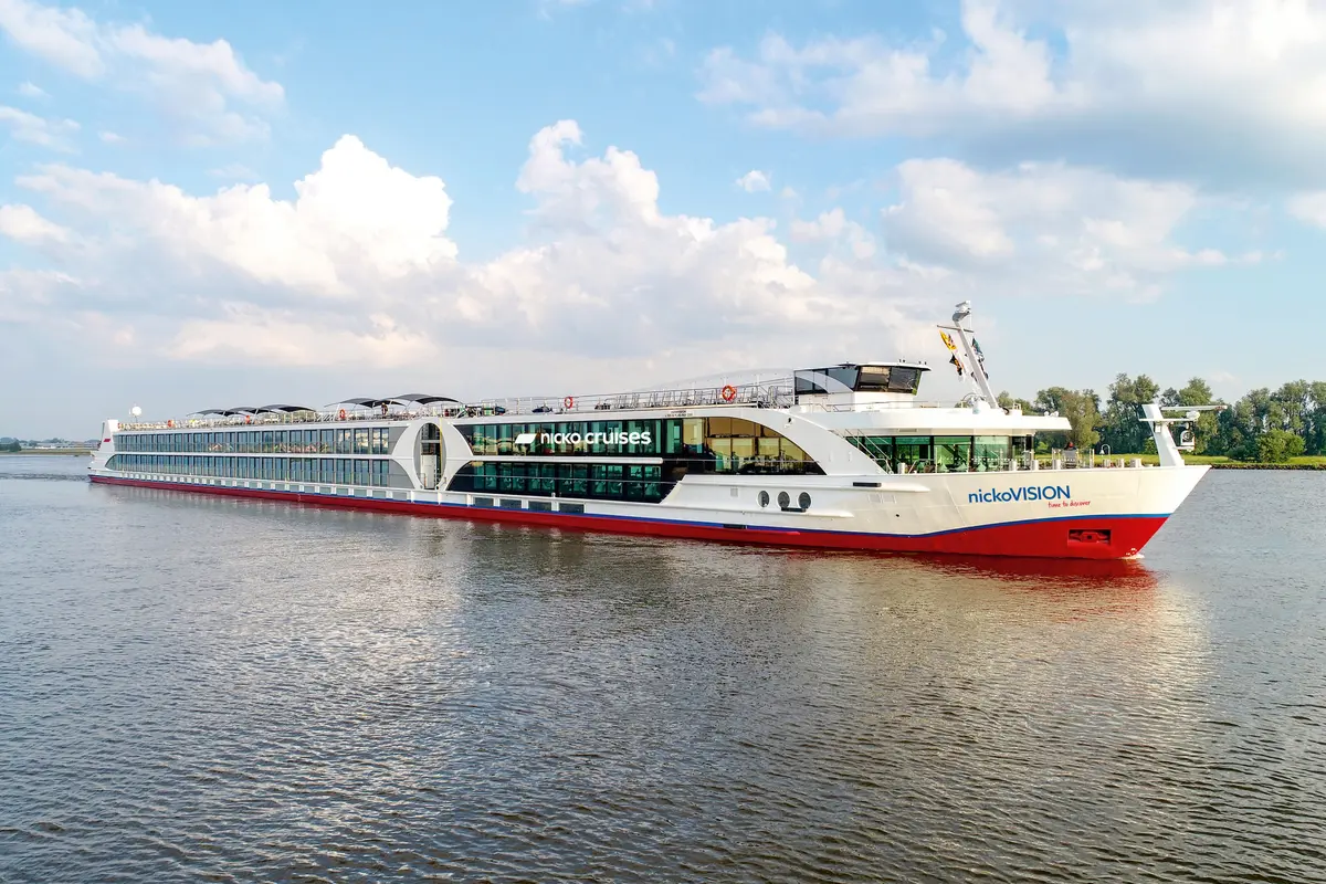 NickoVISION Flusskreuzfahrtschiff bei Tag auf einem Fluss, von der Seite aufgenommen.