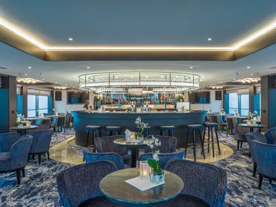 Elegante Lounge mit zentraler Bar, gemütlichen Sitzbereichen und Meerblick.