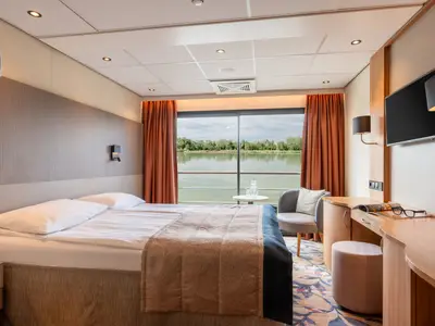Kabine der Rhein Symphonie: Doppelbett, Schreibtisch mit TV, Sessel, Panoramafenster mit Flussblick. Modern und hell.