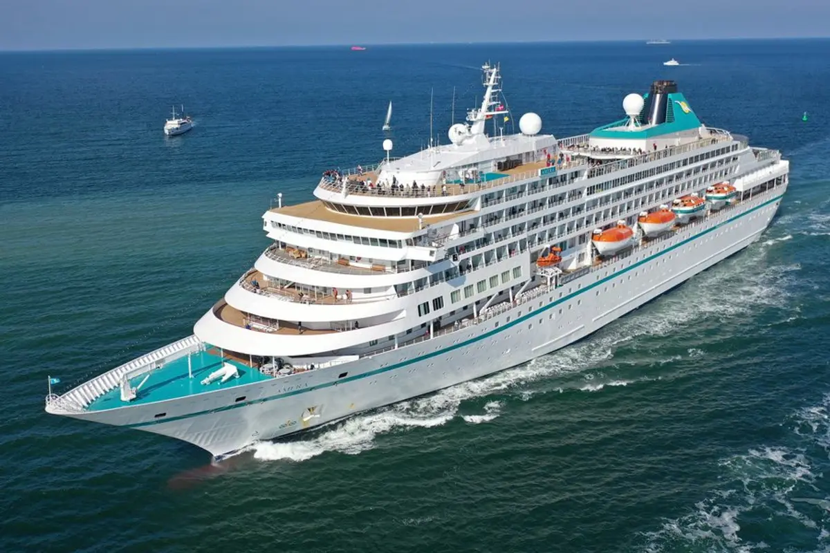 Die MS Amera in einer hochauflösenden Luftaufnahme bei Tageslicht, elegant durch das blaue Meer gleitend. Das Schiff ist von Bug bis Heck sichtbar, mit Passagieren auf den Decks.