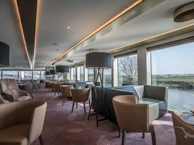 Die moderne Lounge an Bord der MS Andrea bietet bequeme Sitze, große Fenster mit Flussblick und indirekte Deckenbeleuchtung.