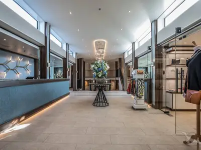 Helle und moderne Rezeption der MS Annabelle. Ein langer Empfangstresen mit blauer Verkleidung, eine große Blumendeko und ein eleganter Shop mit Auslagen sind zu sehen.