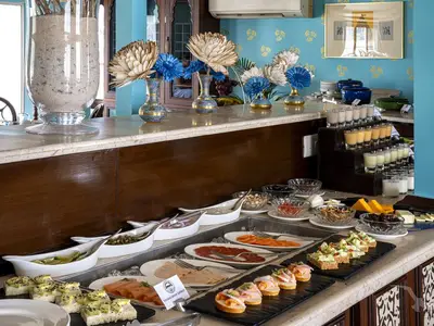 Ein reichhaltiges Buffet an Bord der MS Ganges Voyager mit diversen kalten Speisen, Getränken und Blumendekorationen auf einer Marmortheke.