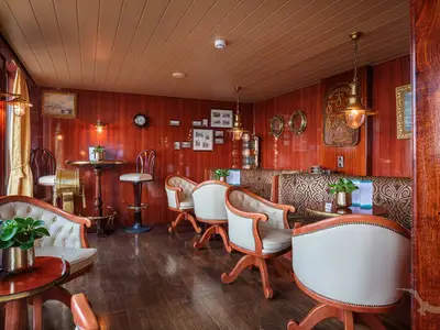 Gemütliche Bar-Lounge an Bord der MS Rhein Prinzessin. Elegante Polstermöbel, dunkle Holzvertäfelung und maritime Dekoration mit Messingdetails prägen den Raum.