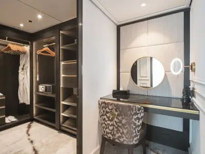 Ein luxuriöser Ankleidebereich und Schminktisch in einer Suite der Riverside Debussy. Links ein begehbarer Schrank, rechts ein Vanity-Tisch mit Spiegeln.